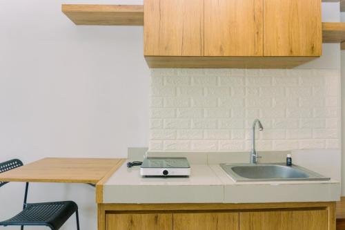 タンゲランにあるComfy and Nice Designed Studio Parkland Avenue Apartment By Travelioのシンクとカウンタートップのあるキッチン