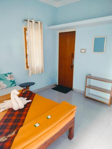 a bedroom with a bed with a towel on it at The Palmyrah Tenements in Mysore