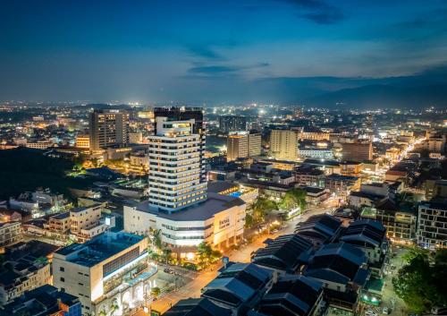 a city lit up at night with buildings at Royal Phuket City Hotel in Phuket Town