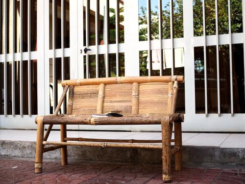 un banc en bois assis devant un bâtiment dans l'établissement Manuhie Backpackers Lodge, à Baher Dar