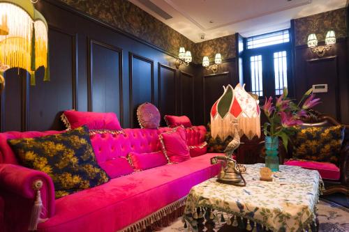 a living room with a pink couch and a table at Beijing Xiaofengxian Former Residence Hotel Tiananmen Square Qianmen Store in Beijing