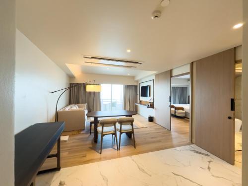 a dining room and living room with a table and chairs at D Varee Jomtien Beach, Pattaya in Jomtien Beach