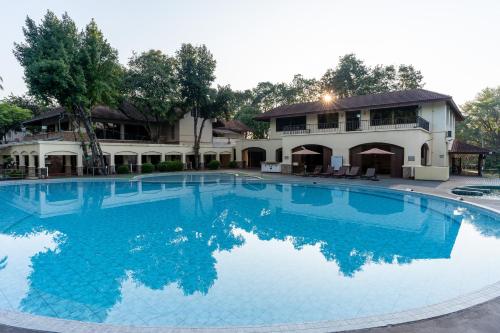 a large swimming pool in front of a house at Pung-Waan Resort & Spa in Kanchanaburi