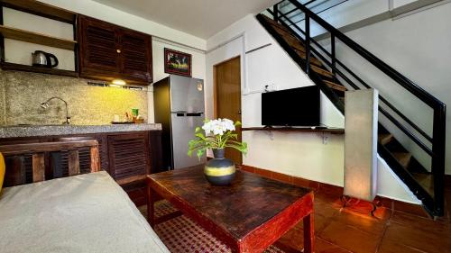a kitchen with a table with a vase of flowers on it at Cozy Paradise in Battambang