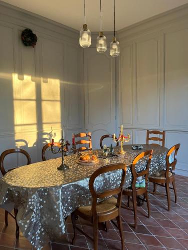 une salle à manger avec une table, des chaises et des bougies dans l'établissement La Charentaise Dorée, à Juillac-le-Coq