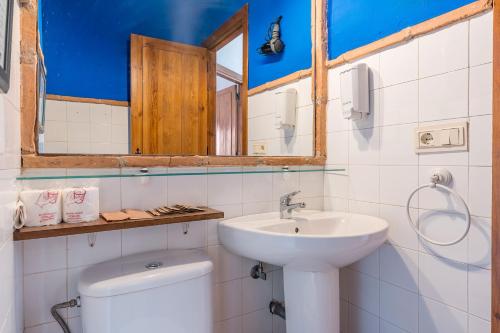 une salle de bain avec un lavabo, des toilettes et un miroir dans l'établissement Apartamento El Tinao, à La Zubia