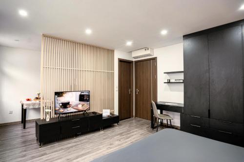 a bedroom with a bed and a desk and a television at Merci Hoang Huy Riverside Hai Phong in Hai Phong