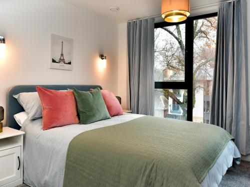 - une chambre avec un lit doté d'oreillers colorés et d'une fenêtre dans l'établissement Pass the Keys Beautiful 3 Bed Town House, à Cardiff