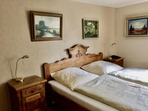 Un dormitorio con dos camas y cuadros en la pared. en Landhaus Heideschmiede, en Undeloh