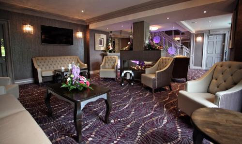 a hotel lobby with couches and chairs and a table at Greenvale Hotel in Cookstown