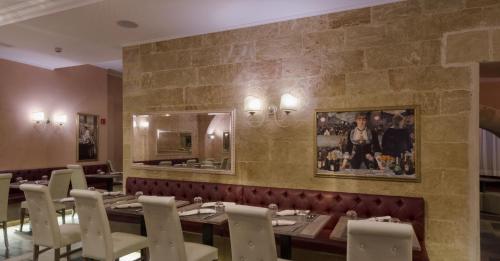 a restaurant with a long table and white chairs at Le Club Boutique Hotel in Lecce