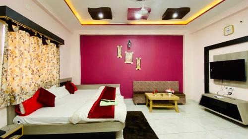 Un dormitorio con una cama grande con una pared morada. en Hotel Adarsh Palace, en Maheshwar
