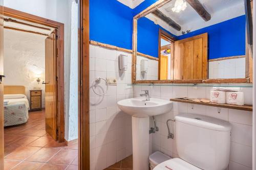 a bathroom with a toilet and a sink and a mirror at Apartamento La Cuadra in La Zubia