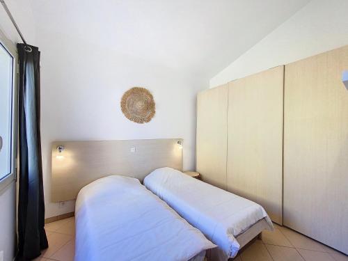 une chambre à l'hôpital avec deux lits et une fenêtre dans l'établissement T3 climatisé avec vue piscine, à Belgodère