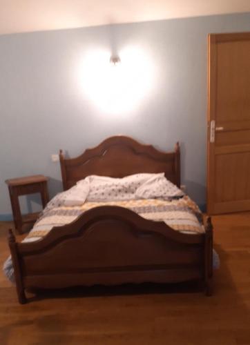 a bedroom with a bed with a light on the wall at les bleuet in Cours