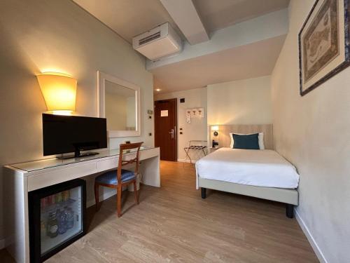 a bedroom with a bed and a tv and a fireplace at Hotel Plaza in Mestre