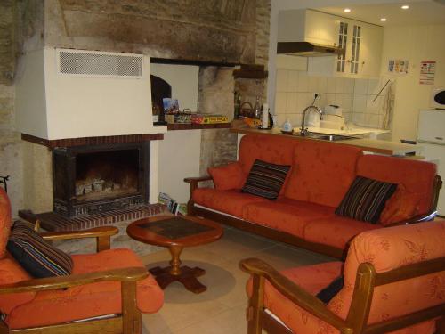 sala de estar con sofá rojo y chimenea en Relais De La Vallée De L'ource en Villars-Montroyer