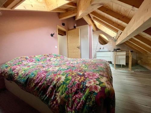 - une chambre avec un lit doté d'une couverture florale dans l'établissement Cocon chaleureux au pied des 3 vallées, à Petit-Coeur