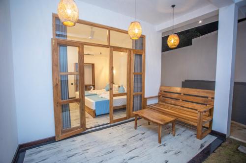 a room with a wooden bench and a bedroom at MJ Haven Point in Ahangama