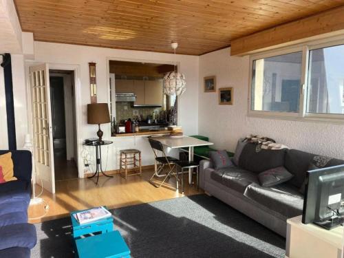 un salon avec un canapé et une cuisine dans l'établissement Résidence Saint Laurent - APPARTEMENT ALPE D'HUEZ QUARTIER VIEL ALPE MAE-9501, à Huez