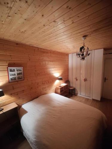 - une chambre avec un lit blanc dans un mur en bois dans l'établissement Résidence Saint Laurent - APPARTEMENT ALPE D'HUEZ QUARTIER VIEL ALPE MAE-9501, à Huez