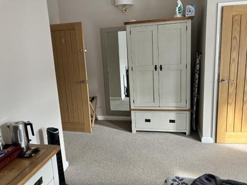 a room with a white cabinet and a mirror at Sixteen B in York
