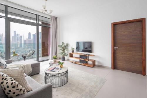 a living room with a couch and a tv at Frank Porter - Park Gate in Dubai