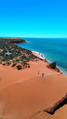 a group of people walking on the beach at Wildsights Beach Units in Denham