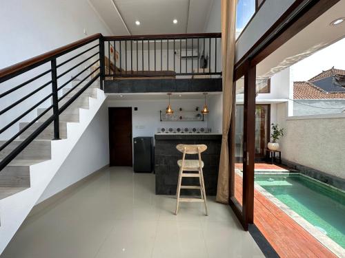 a kitchen and swimming pool in a house with a staircase at Lajimbar Villa in Ketewel