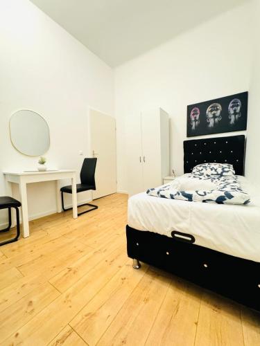 a bedroom with a bed and a desk and a mirror at Convenient Stay 4BR Shared Apt for 11P, 10 Min to Atzgersdorf in Vienna