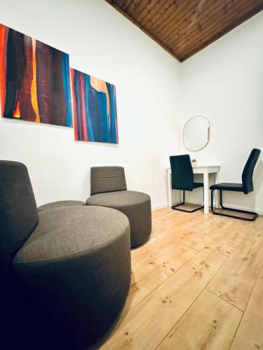 a living room with two chairs and a table at Convenient Stay 4BR Shared Apt for 11P, 10 Min to Atzgersdorf in Vienna