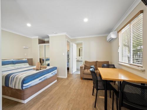 a bedroom with a bed and a dining room at Mandalay Holiday Resort and Tourist Park in Busselton