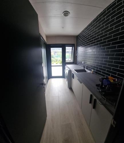 a kitchen with a sink and a brick wall at Lake Opuha House in Ashwick Flat