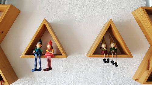three wooden shelves with toy figurines on a wall at The Red Hotel in Nanwan