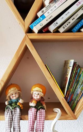 two dolls are sitting in a book shelf at The Red Hotel in Nanwan