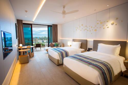 a hotel room with two beds and a living room at Sanya Conifer Resort in Sanya