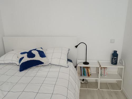 - une chambre blanche avec un lit et une lampe dans l'établissement Mignon appartement , Nîmes center, à Nîmes