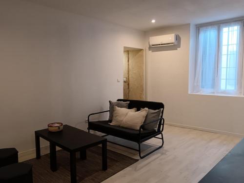 - un salon avec une chaise noire et une table dans l'établissement Mignon appartement , Nîmes center, à Nîmes