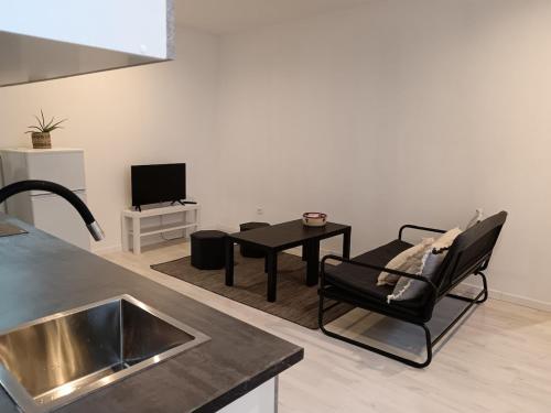 une cuisine avec un évier et une table avec une chaise dans l'établissement Mignon appartement , Nîmes center, à Nîmes