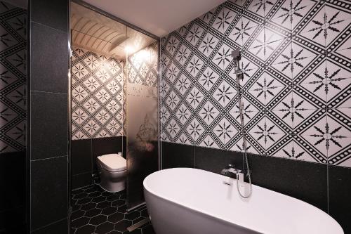a bathroom with a toilet and a white tub at El Tower Hotel in Gunsan