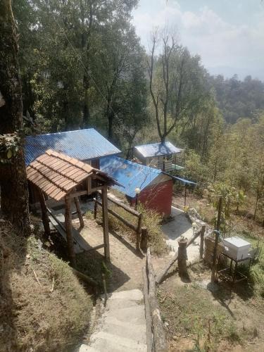 a house with a blue roof and a table at Jungle Crown Organic Homestay in Nagarkot