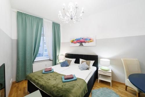 Un dormitorio con una cama, una mesa y una lámpara de araña. en Grand Central City Apartments Mitte Rosenthaler Platz, en Berlín