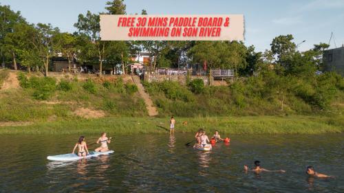 a group of people swimming on surfboards in the water at Green Riverside Cosy Home in Phong Nha