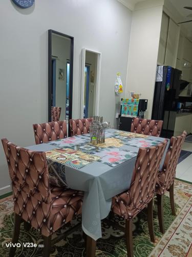 a dining room table with leather chairs and a tablecloth at HANS HOMESTAY in Lumut