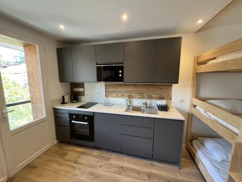 une petite cuisine avec un évier et une cuisinière dans l'établissement Les Clarines, à Val dʼIsère