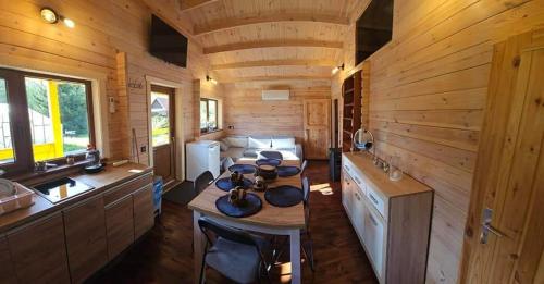 una cocina con mesa en una cabaña de madera en Sodyba pas Martyna, en Triušiai
