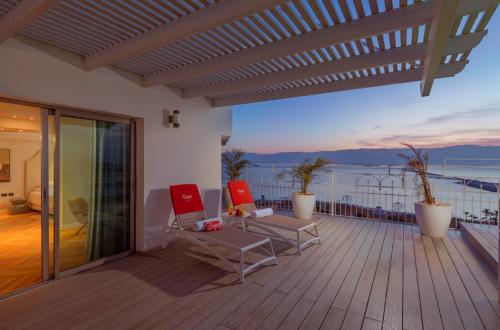 a balcony with chairs and a view of the ocean at Enjoy Dead Sea Hotel in Ein Bokek