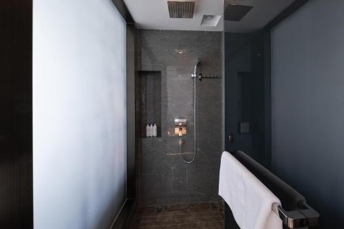 a bathroom with a shower with a walk in shower at Mehood Lestie, Qingdao Qingdao Jiaodong Airport Jiaozhou Baolong Plaza in Jiaozhou
