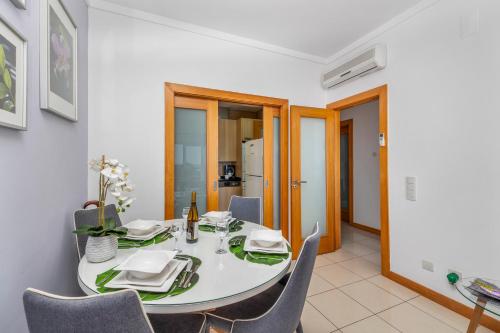 a dining room with a white table and chairs at Quinta da Barracuda Prime Sea View Apartment in Albufeira