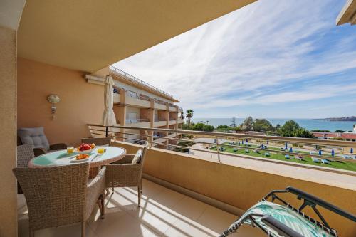 a balcony with a table and chairs and a view of the ocean at Quinta da Barracuda Prime Sea View Apartment in Albufeira